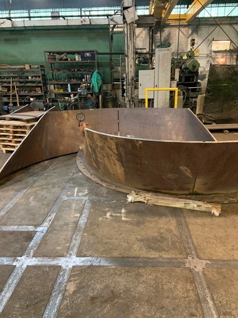 A large rolled and welded steel plate structure on the shop floor