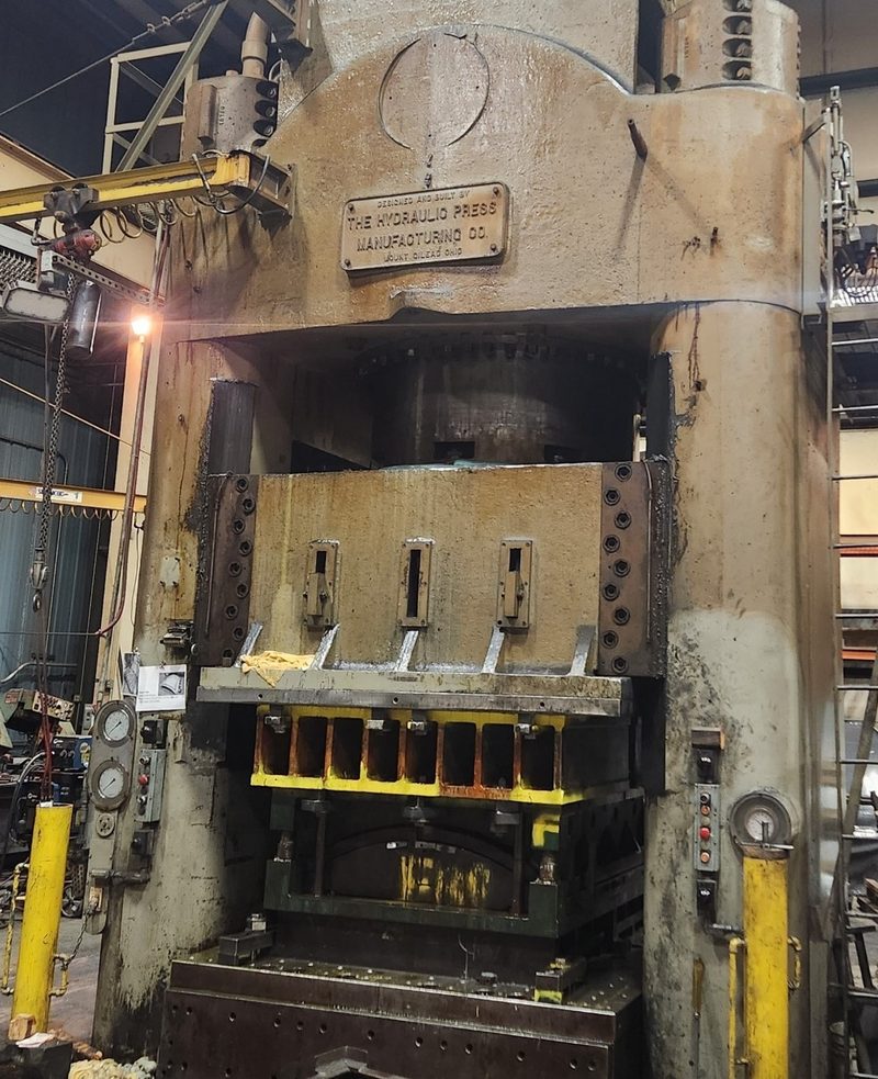 A large hydraulic stamping press with a die set in place