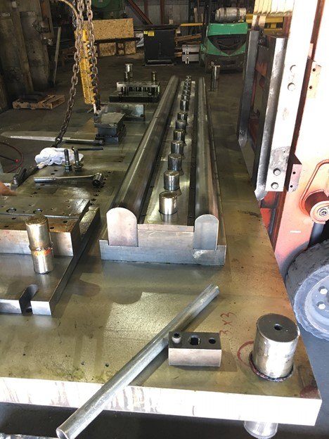 A long stamping die with guide posts set out on the plant floor