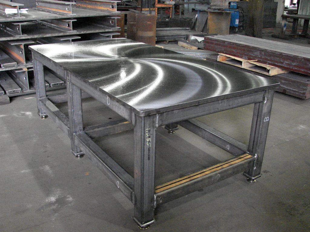 A welded steel frame with a ground plate top in a fabrication shop